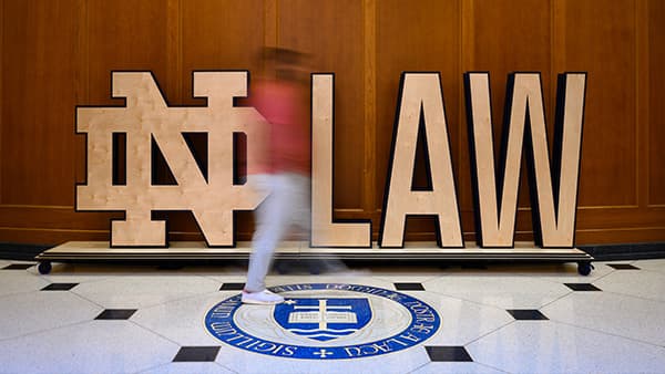Wooden ND Law sign with blurred student walking in foreground