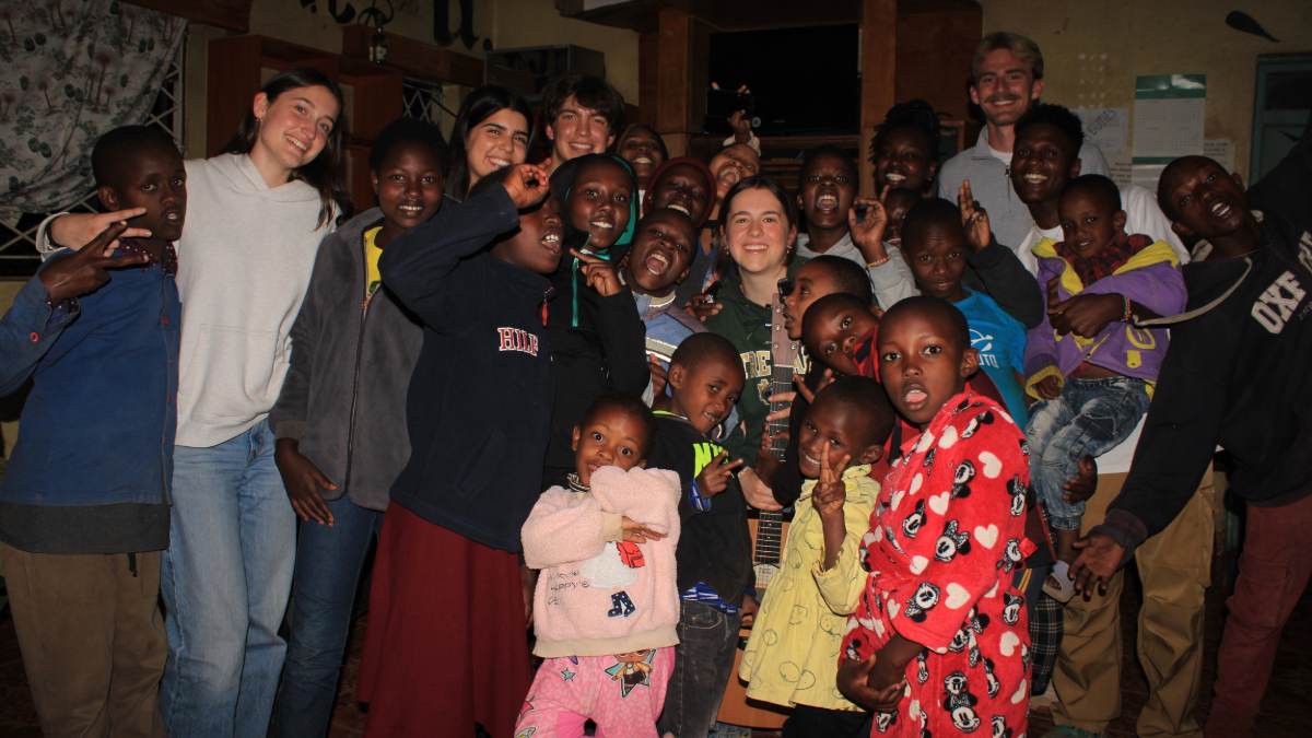 Group of kids and Anna, smiling inside the local children's home